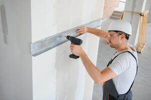 Construction worker installing metal profile for interior partition wall, while building a new house or renovation process photo