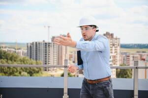 Engineer with tablet, building inspection. Construction man in helmet build new house photo