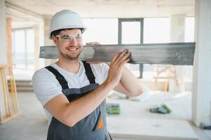 Builder in working uniform cutting metal profile with cutting machine at the construction site indoors photo