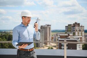 Engineer with tablet, building inspection. Construction man in helmet build new house photo