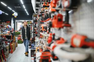 A man chooses a power tool in a hardware store photo