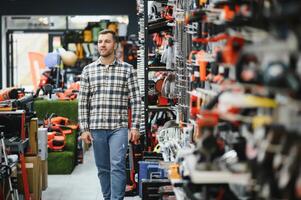 A man chooses a power tool in a hardware store photo