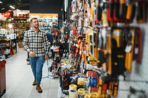 A man in a hardware store choosing a tool photo