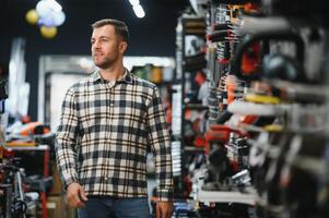 A man chooses a power tool in a hardware store photo