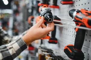 A man in a hardware store choosing a tool photo