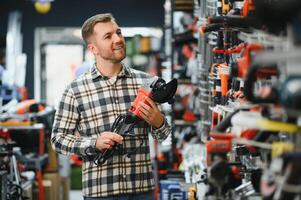 A man chooses a power tool in a hardware store photo