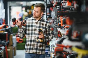 A man chooses a power tool in a hardware store photo