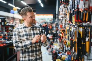 A man in a hardware store choosing a tool photo