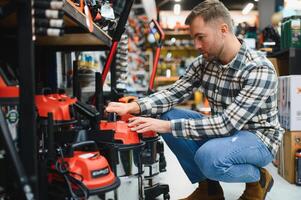 A man in a hardware store choosing a tool photo