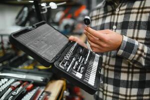 A man in a hardware store choosing a tool photo
