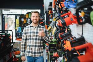 A man in a hardware store choosing a tool photo