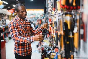 An African American man chooses tools in a hardware store photo