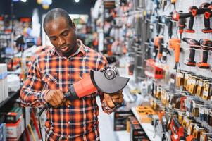 A african american man chooses a power tool in a hardware store photo