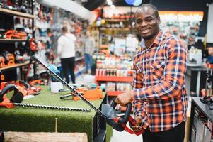 A african american man chooses a power tool in a hardware store photo
