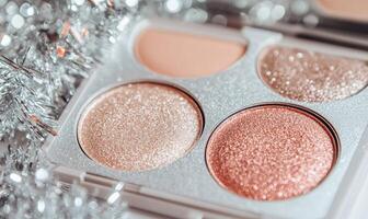 A palette of two eyeshadow shades light tan, soft peach with silver tinsel scattered delicately around the palette photo