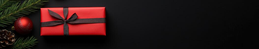 Festive red gift box with holiday decorations on dark background photo