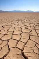 Dry cracked earth under a clear blue sky in a vast landscape photo