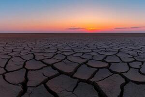 Cracked earth under a stunning sunset in the desert photo