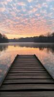 Sunrise over calm waters by a wooden dock in the morning photo