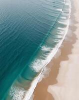 Aerial view of turquoise ocean waves crashing on sandy beach photo