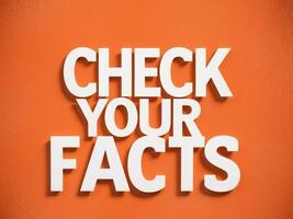 Bold Check Your Facts Message with Dynamic White Typography on Bright Orange Background. photo