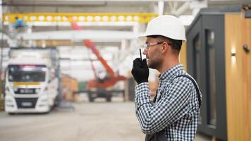 Foreman manages the loading of a prefabricated modular house to truck using walkie talkie video