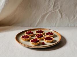 Redcurrant tartlets on a plate on light rustic background. photo