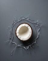 Coconut shell surrounded by splashes of refreshing water in a creative display photo
