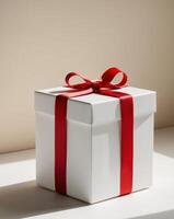 A white box with a red ribbon and a red bow on top photo