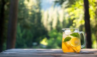 A refreshing pitcher of iced tea with lemon and mint in a serene forest. photo