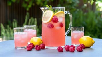 Refreshing raspberry lemonade served in a pitcher with ice and lemons. photo