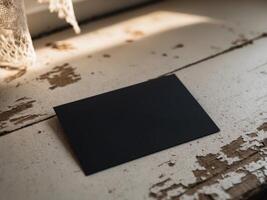 Simple black card placed on a textured surface illuminated by soft natural light. photo