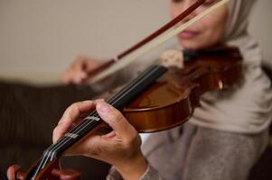 Close-up of woman playing violin with focus on hands and instrument photo