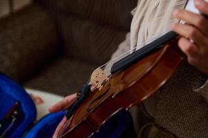 Close-up of hands holding a violin in a cozy setting photo