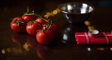 Fresh tomatoes with kitchen utensils on a dark wooden table photo