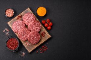 Fresh raw ground beef burger patty with salt and spices photo