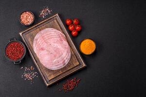 Smoked ham with salt, spices and herbs cut into round slices photo