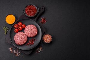 Fresh raw ground beef burger patty with salt and spices photo