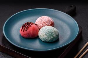 Delicious colorful asian mochi sweets with rice dough shell and fruit filling photo