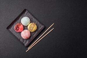 Delicious colorful asian mochi sweets with rice dough shell and fruit filling photo