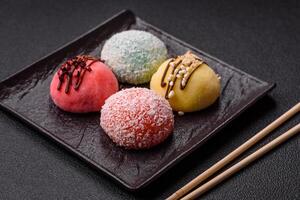 Delicious colorful asian mochi sweets with rice dough shell and fruit filling photo