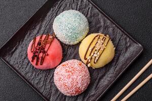 Delicious colorful asian mochi sweets with rice dough shell and fruit filling photo