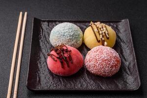 Delicious colorful asian mochi sweets with rice dough shell and fruit filling photo