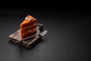 Piece of sweet layer cake with pumpkin or citrus flavor with cream photo