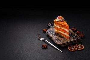 Piece of sweet layer cake with pumpkin or citrus flavor with cream photo
