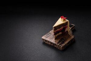 Piece of sweet layered cheesecake with cherries and poppy seeds photo
