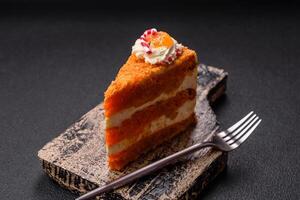 Piece of sweet layer cake with pumpkin or citrus flavor with cream photo