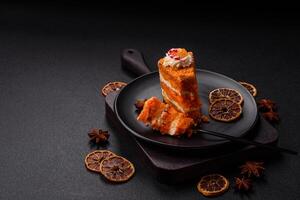 Piece of sweet layer cake with pumpkin or citrus flavor with cream photo