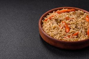 Delicious fresh pilaf with rice, carrots, meat, onions, spices and berries photo