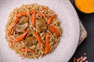 Delicious fresh pilaf with rice, carrots, meat, onions, spices and berries photo
